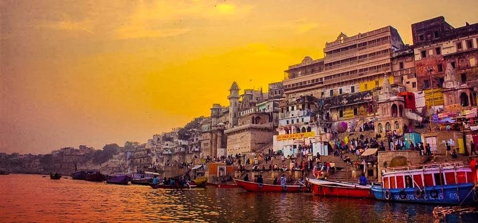 Sunrise over the Varanasi ghats on the Ganga with rowing boats on the water